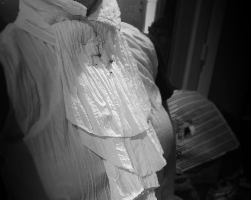  a woman wearing a Victorian style lace collar, pinned and ready for sewing