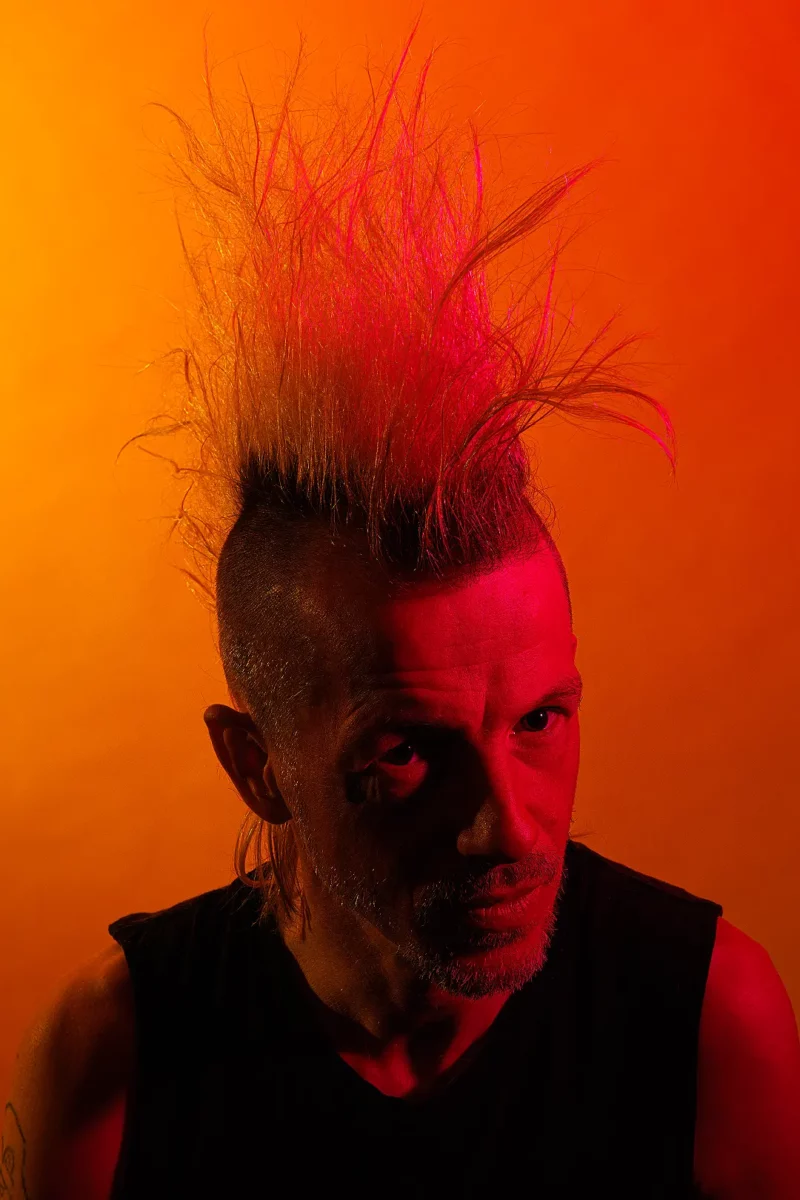 Studio portrait of Karl Ekdahl in full mohawk bloom in red and orange gels photographed at the Puptrait Studio in Baltimore, Maryland